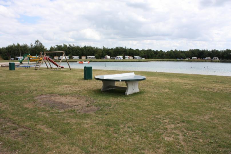 Betonnen pingpongtafel rond groen op speelveld camping