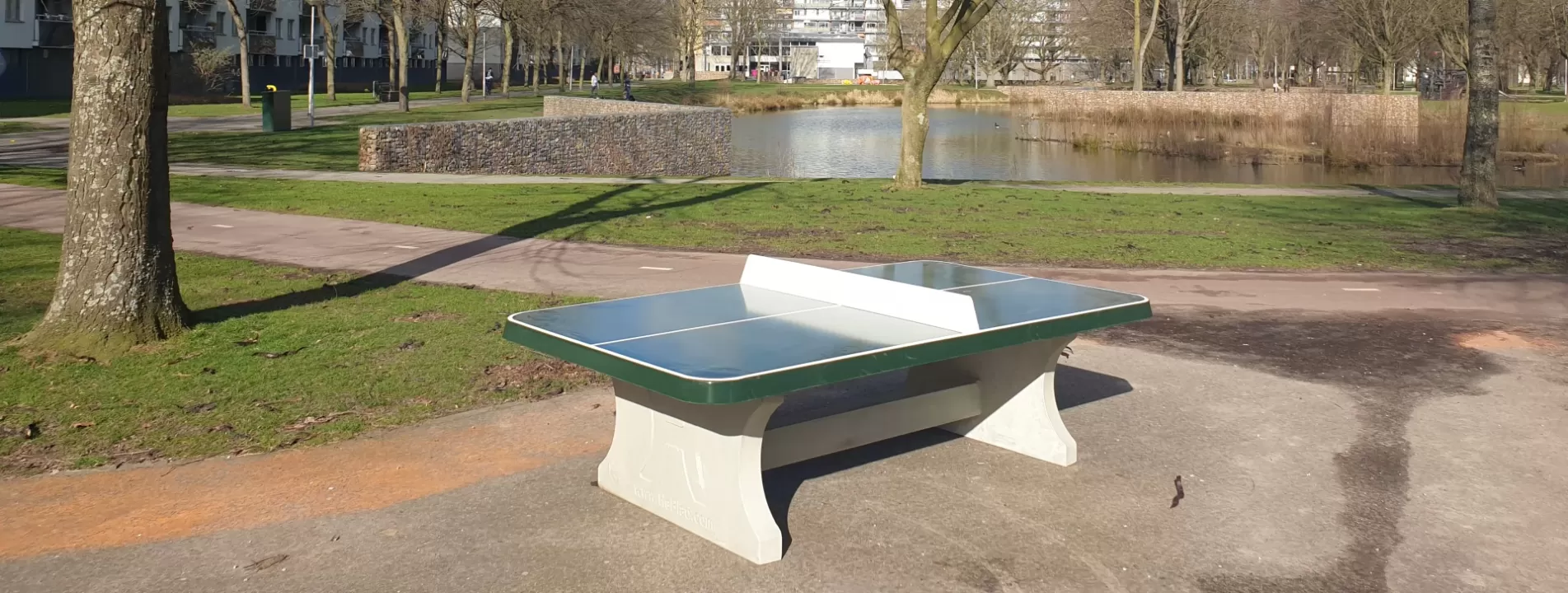 Groene afgeronde betonnen pingpongtafel in buitengebied